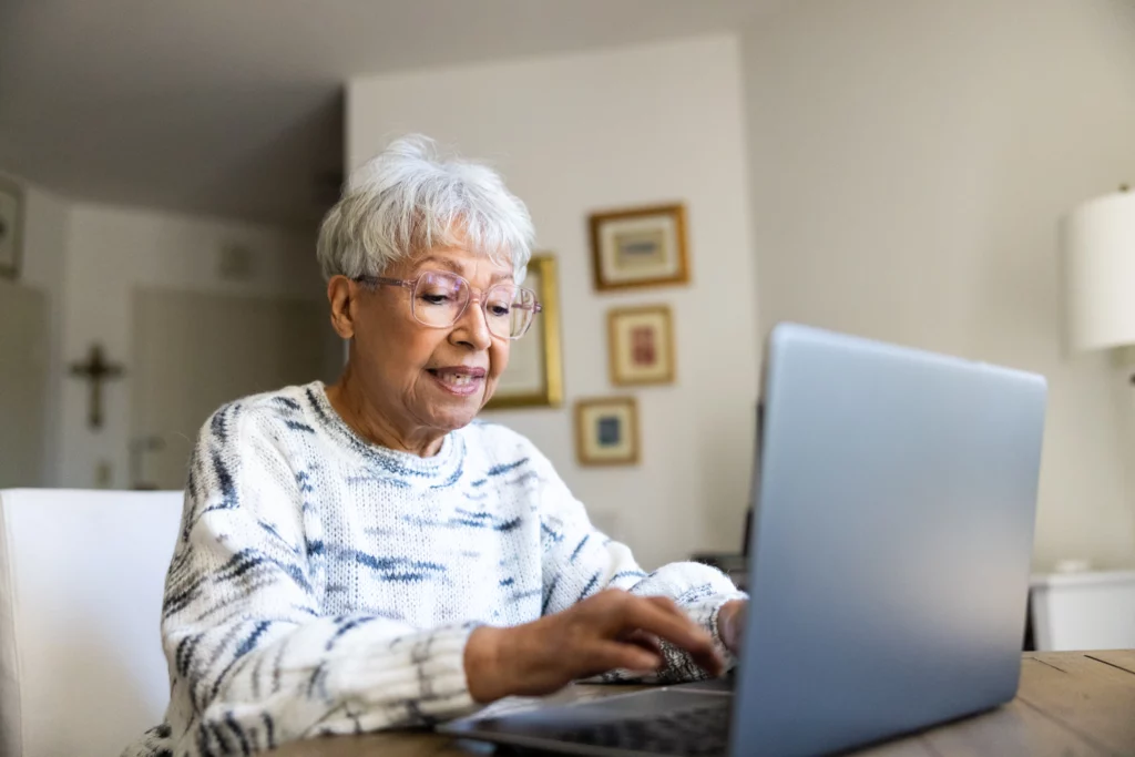 Senior woman using a laptop computer in her suite, learning about how to avoid digital scams