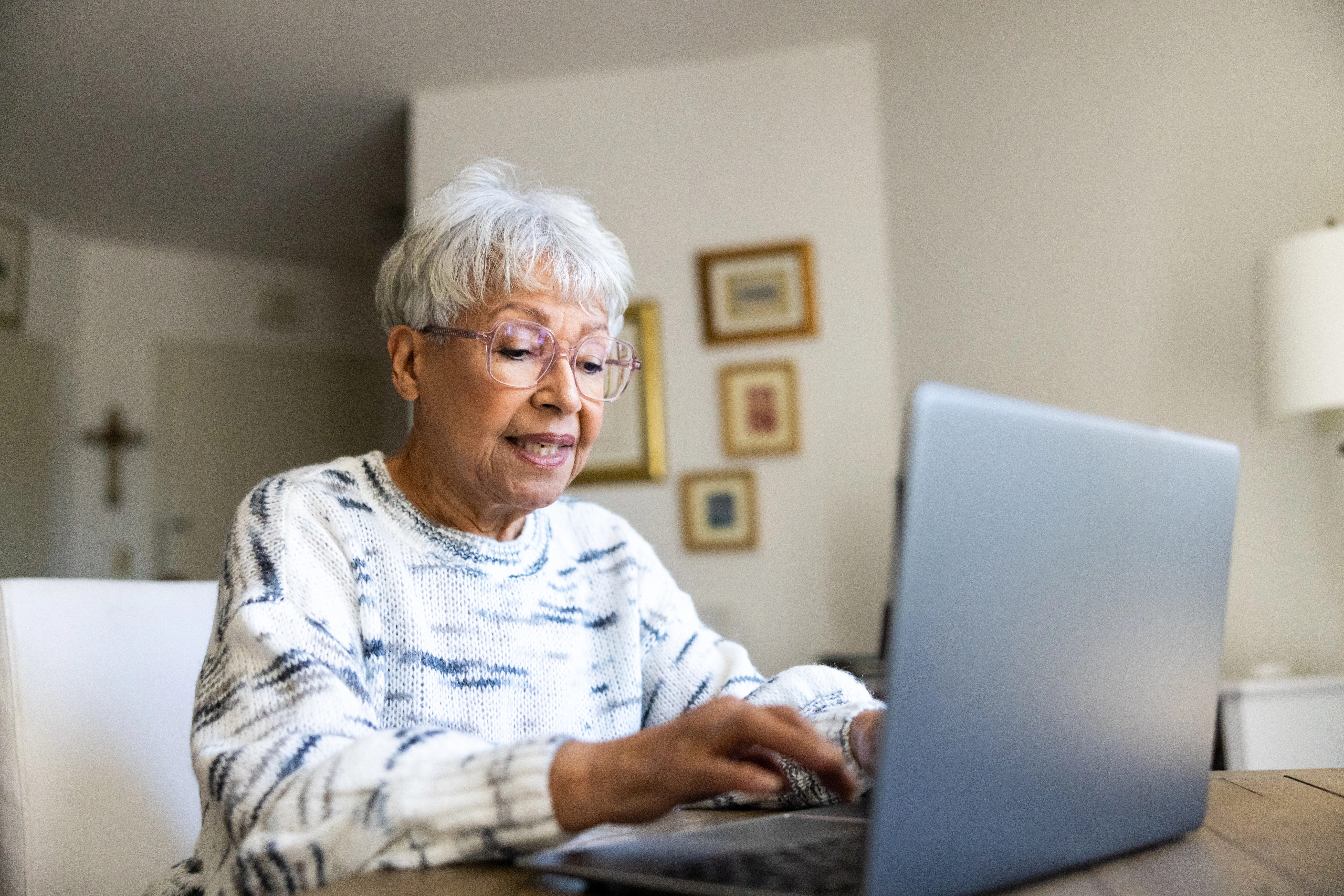 Senior woman using a laptop computer in her suite, learning about how to avoid digital scams